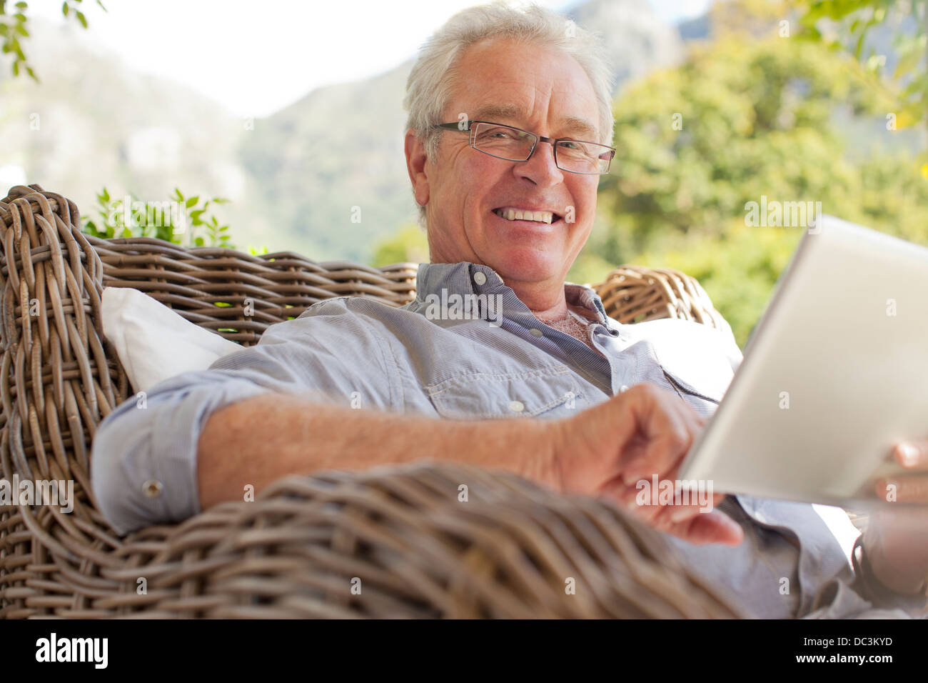 Portrait of smiling man using digital tablet on patio Banque D'Images