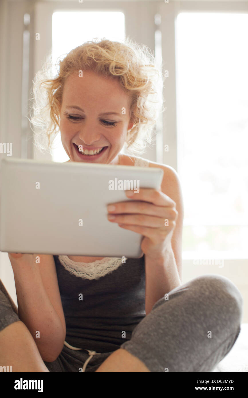 Smiling woman using digital tablet Banque D'Images