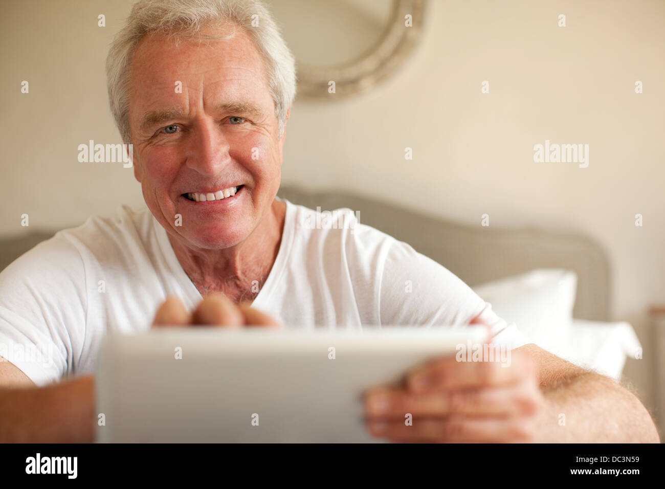 Portrait of smiling senior woman using digital tablet in bedroom Banque D'Images