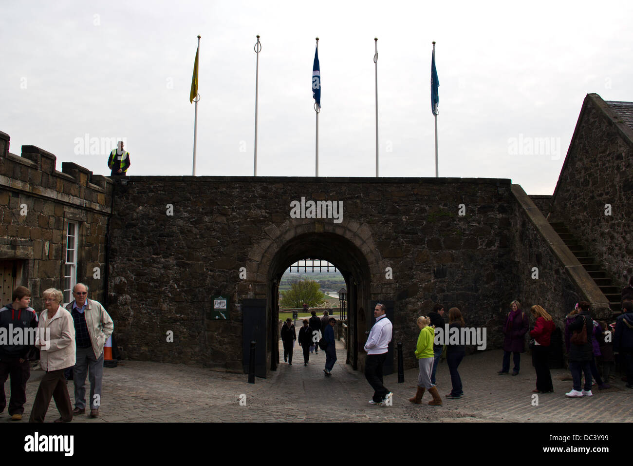 Les touristes à l'intérieur du château de Stirling en Écosse près de l'entrée, avec des drapeaux au-dessus de l'entrée, y compris le sautoir Banque D'Images