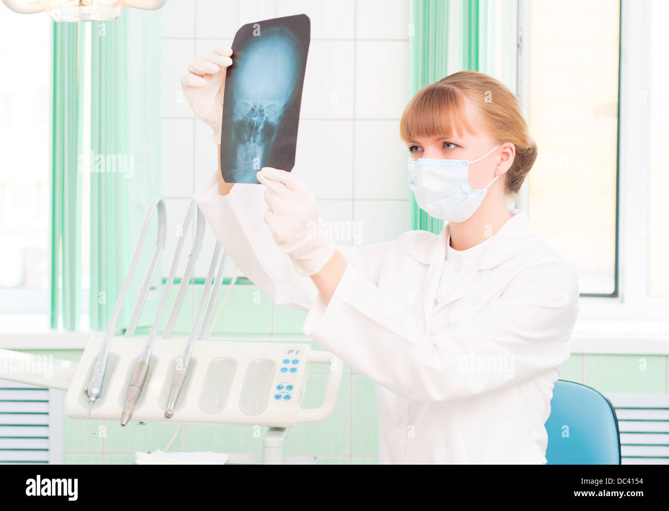 Jeune femme médecin regarde une radiographie de crâne Banque D'Images