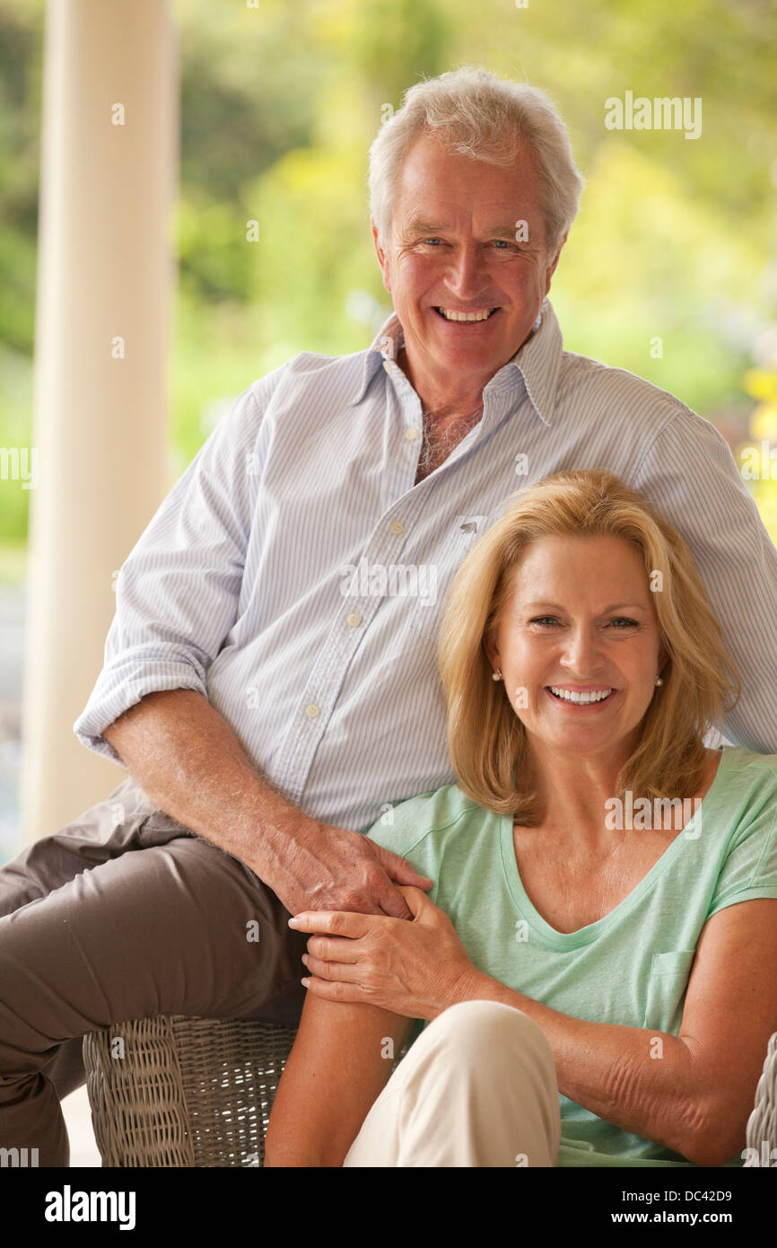 Portrait of smiling couple holding hands on patio Banque D'Images