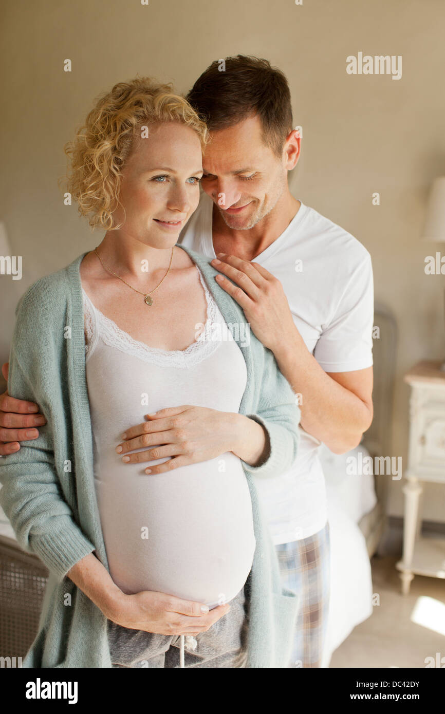 Smiling man hugging pregnant woman Banque D'Images