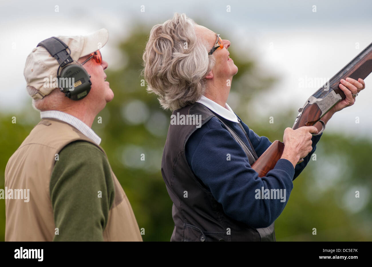 Un fusil de tir dame à un jeu de simulation de tir d'argile 24, aidé par un chargeur Banque D'Images
