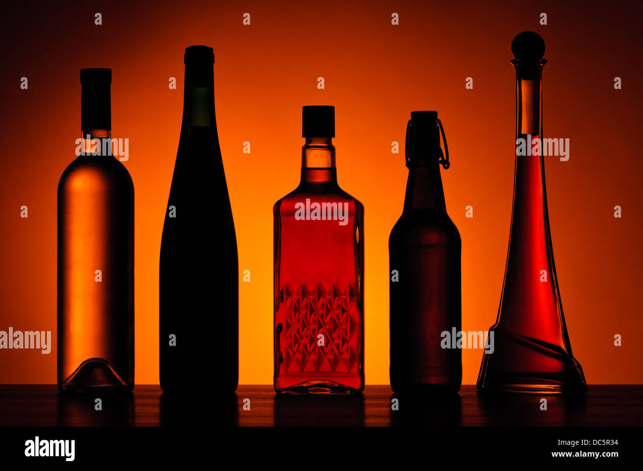 Différentes bouteilles de boissons alcoolisées sur une table en bois Banque D'Images