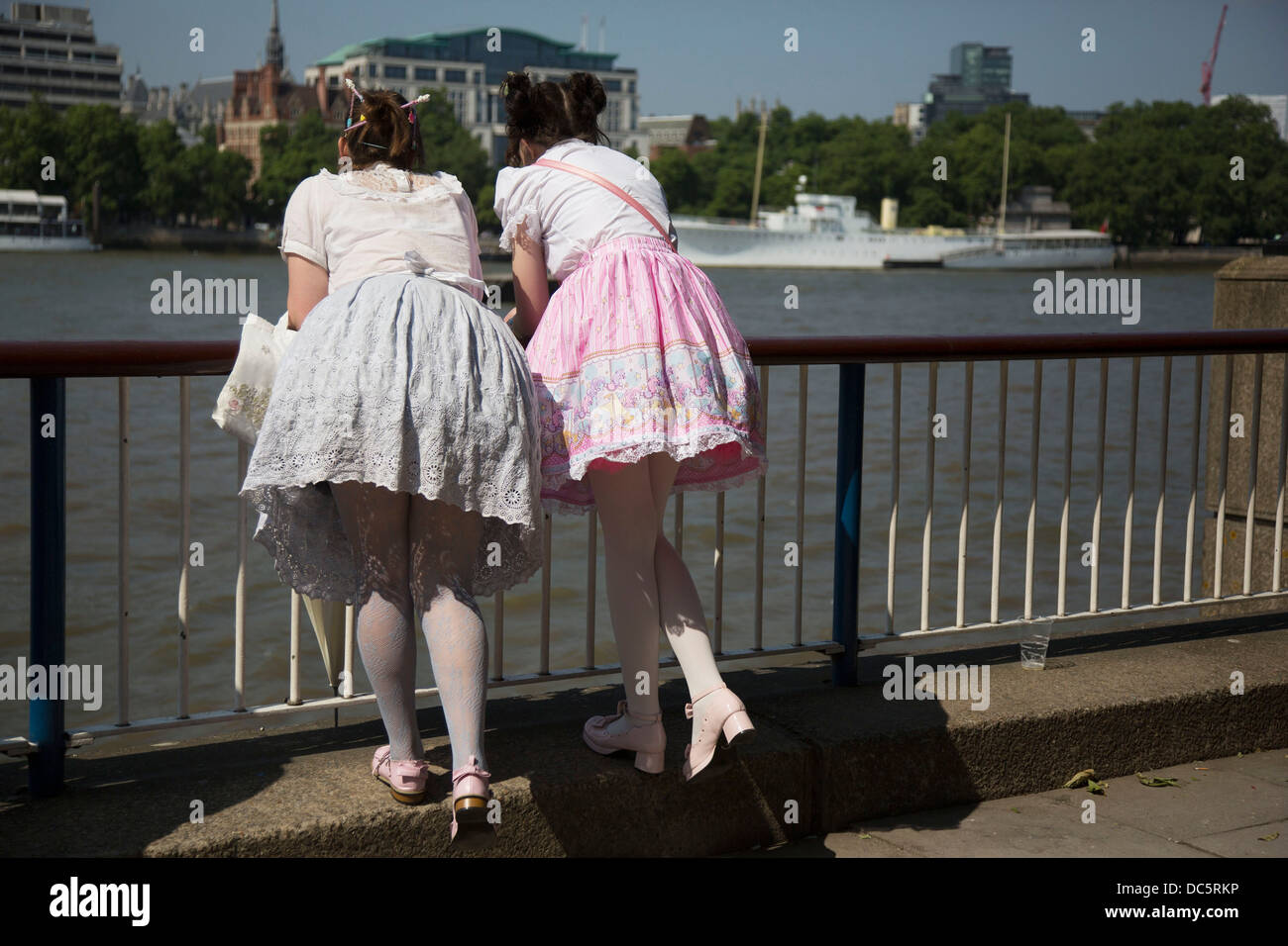 Deux jeunes filles portant des robes Lolita se pencher par-dessus la  barrière sur la Tamise sur la rive sud, Londres, Royaume-Uni. Lolita  fashion est une sous-culture originaires du Japon qui est basé