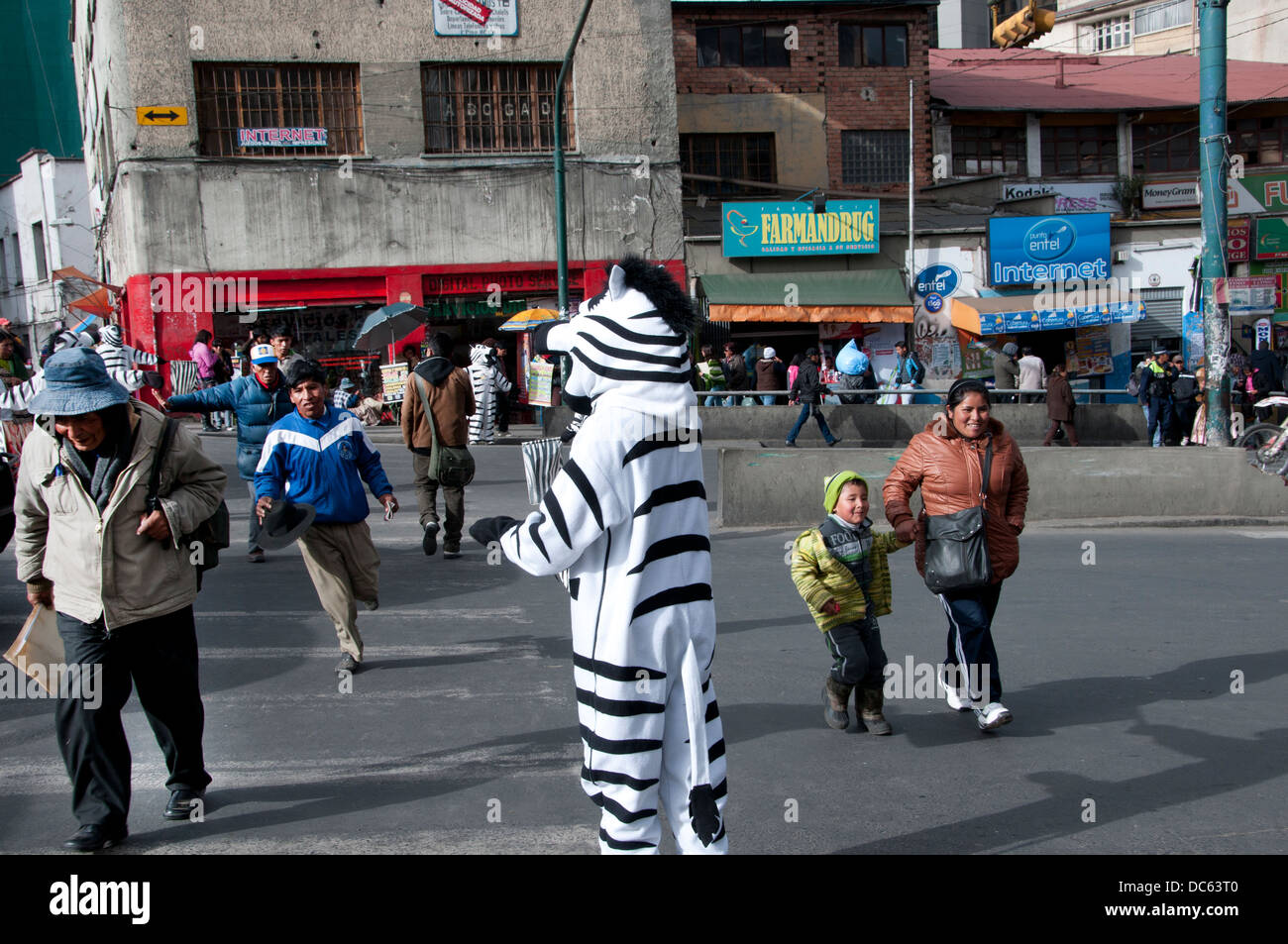 Les jeunes gens habillés comme des zèbres aident à contrôler le trafic pendant les heures de pointe de l'après-midi afin que les gens peuvent utiliser le passage à niveau. Banque D'Images