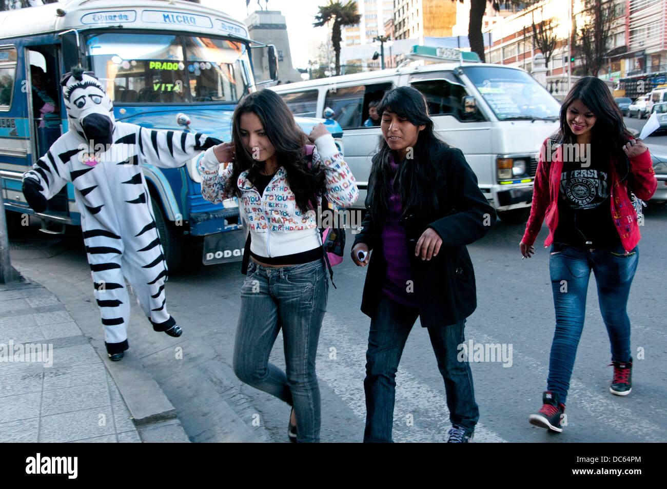 Les jeunes gens habillés comme des zèbres aident à contrôler le trafic pendant les heures de pointe de l'après-midi afin que les gens peuvent utiliser le passage à niveau. Banque D'Images