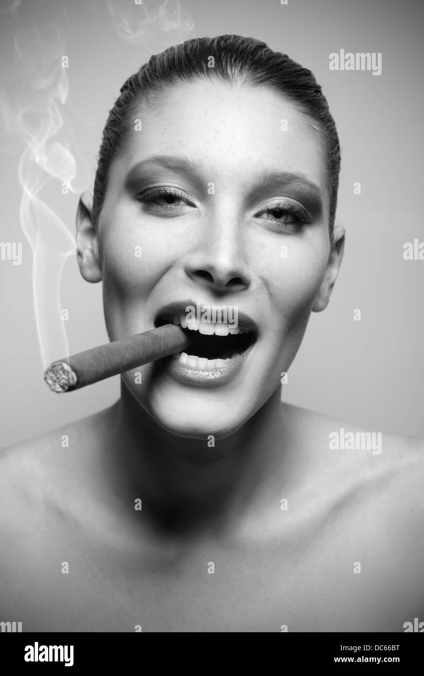 Jolie jeune femme fumant un cigare Banque D'Images