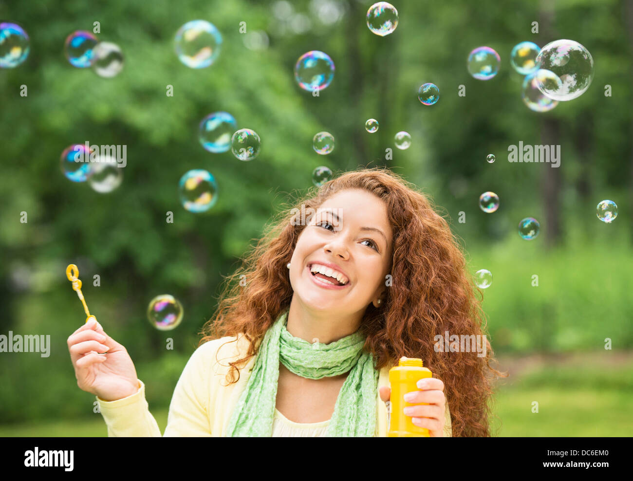 Young woman blowing bubbles in park Banque D'Images