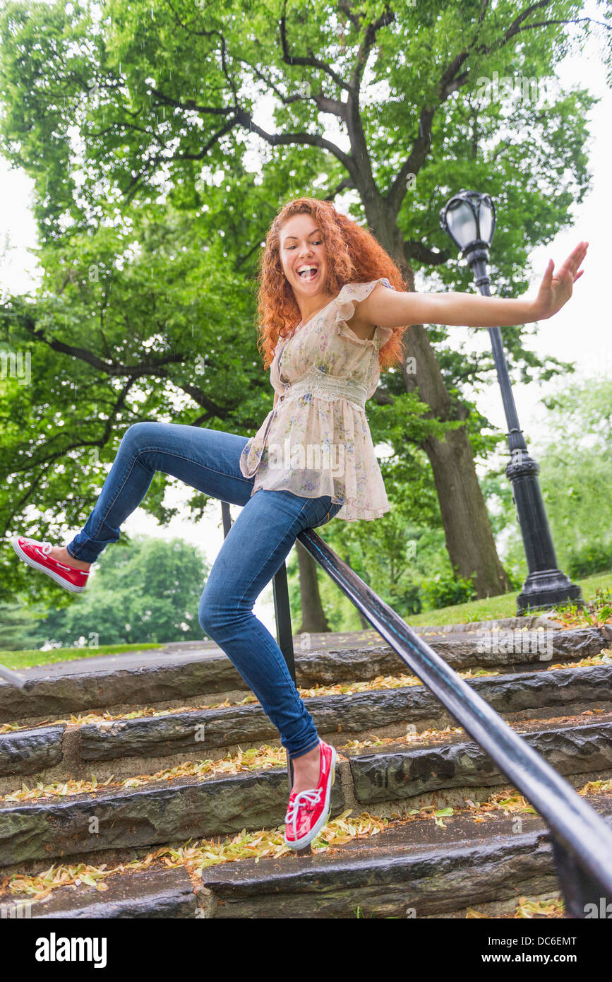 USA, New York, New York, Central Park, femme glisser sur rambarde dans park Banque D'Images
