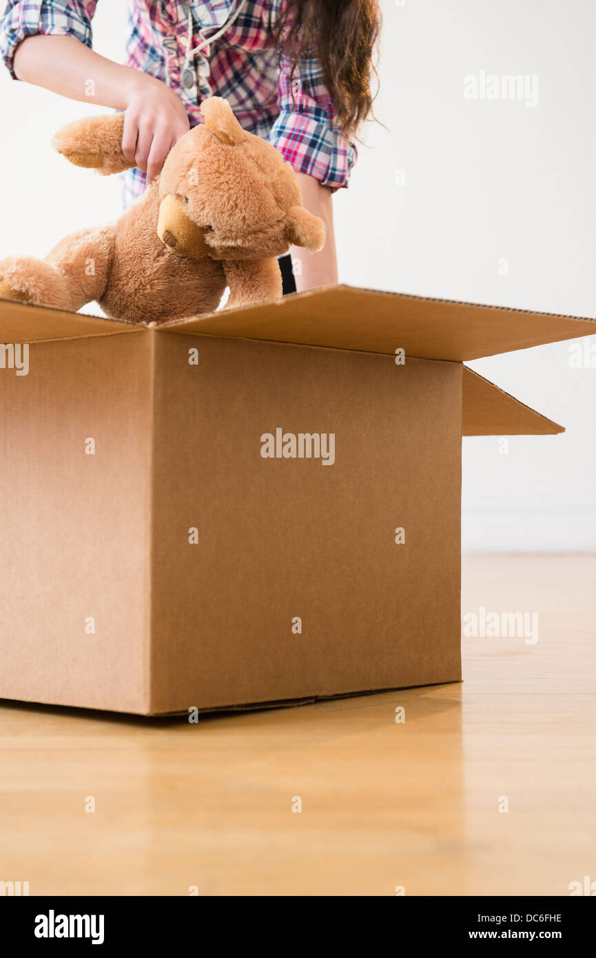 Girl (8-9) l'emballage en carton pour l'ours en peluche Photo Stock - Alamy