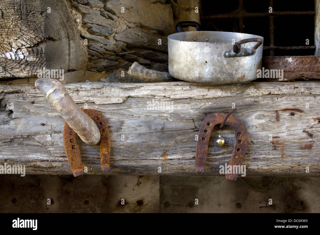 Horse Shoe, corne et vieux pots sur une poutre en bois Banque D'Images