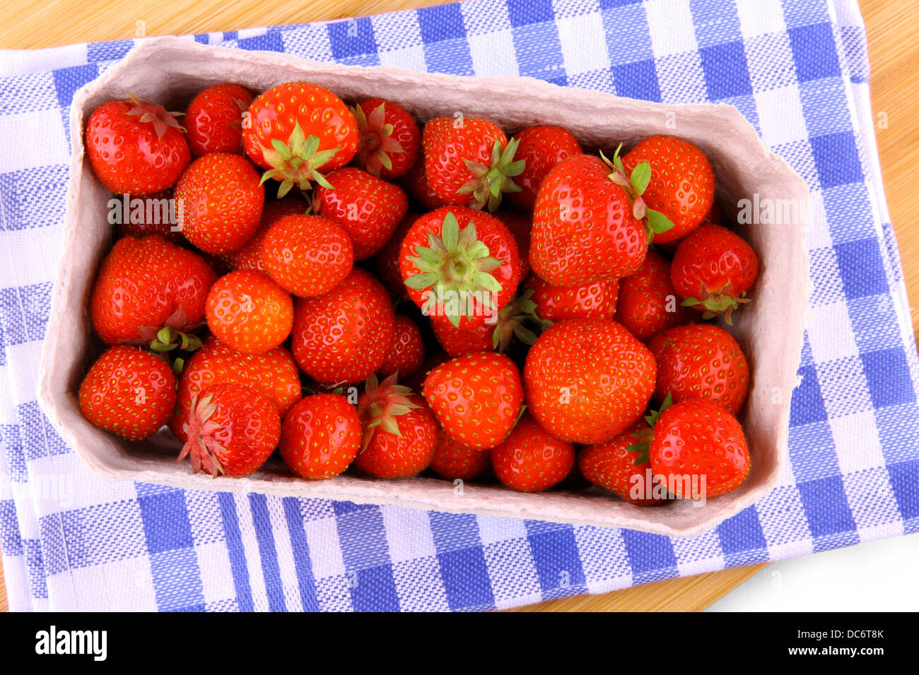 Des fraises fraîches dans du papier fort sur fond bleu-blanc, vue du dessus Banque D'Images