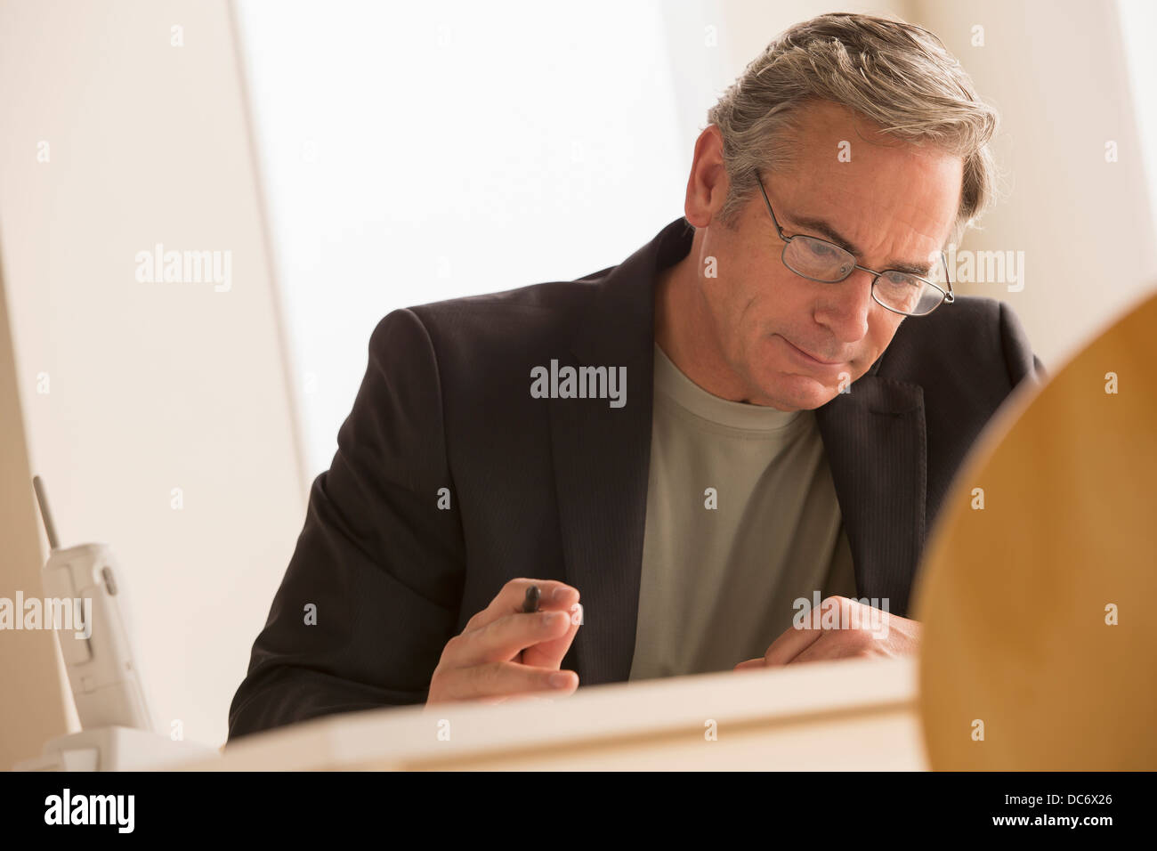 L'homme d'affaires d'âge mûr se concentrant sur travailler Banque D'Images