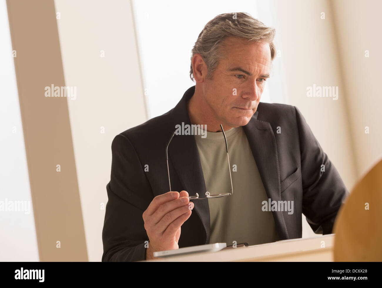 L'homme d'affaires d'âge mûr se concentrant sur travailler Banque D'Images