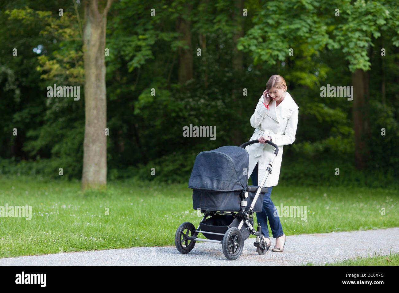 Aux Pays-Bas. Haye, mère de la pram dans park talking on mobile phone Banque D'Images