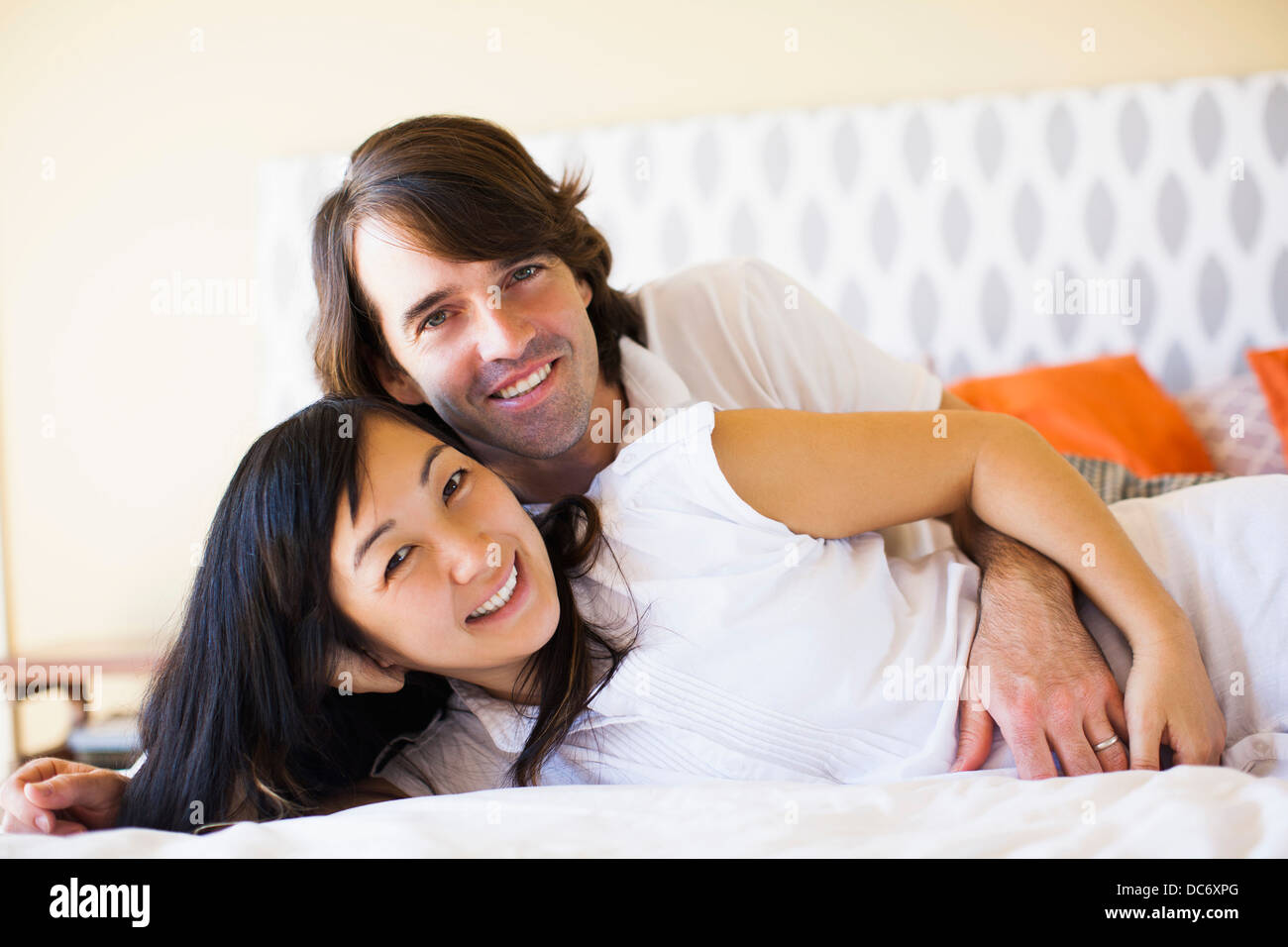 Femme enceinte avec le mari de câlins sur le lit Banque D'Images