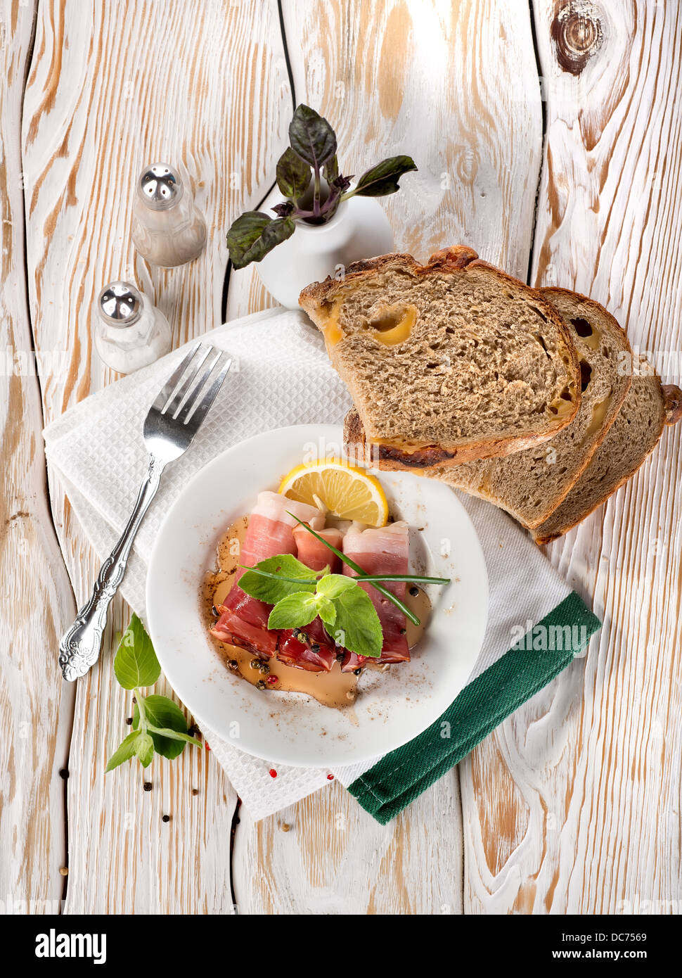 Du bacon et du pain sur une table en bois blanc Banque D'Images