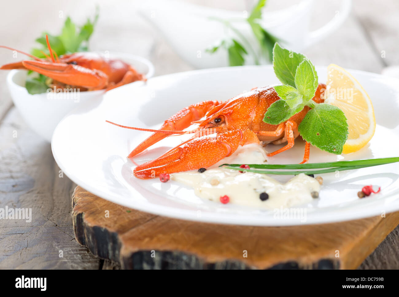 Deux homards rouges avec la sauce, les verts et les citrons Banque D'Images