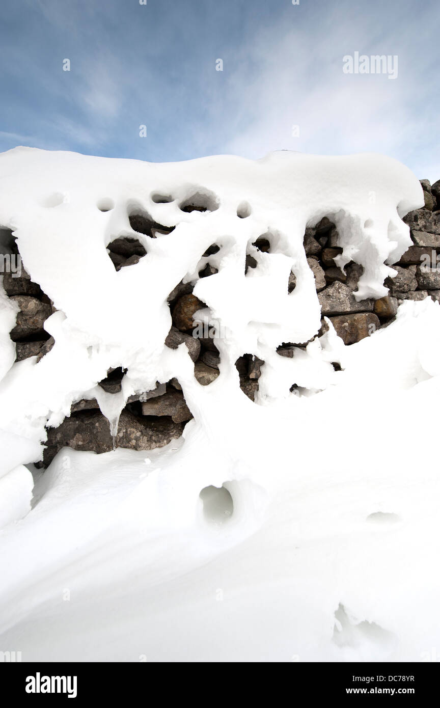 Dans les modèles à Snowdrift arrière d'un mur de pierres sèches après tempête, Cumbria, Royaume-Uni Banque D'Images