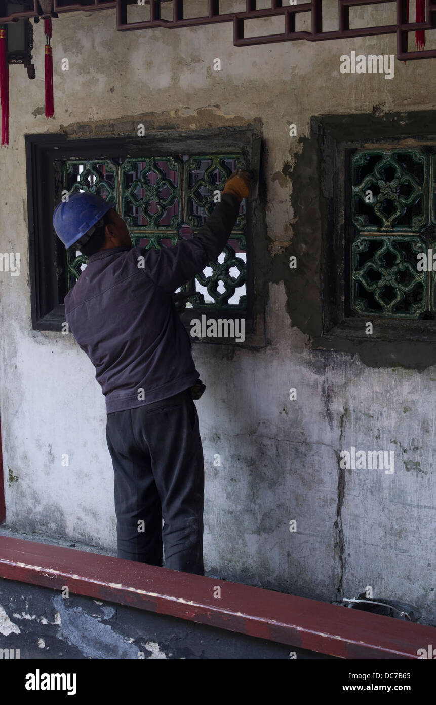 Ouvrier d'effectuer des réparations au Yu Garden / Jardin Yuyuan, au Jardin Chinois situé à côté de la ville, Vieille Ville Temple Gog, Shanghai, Chine Banque D'Images