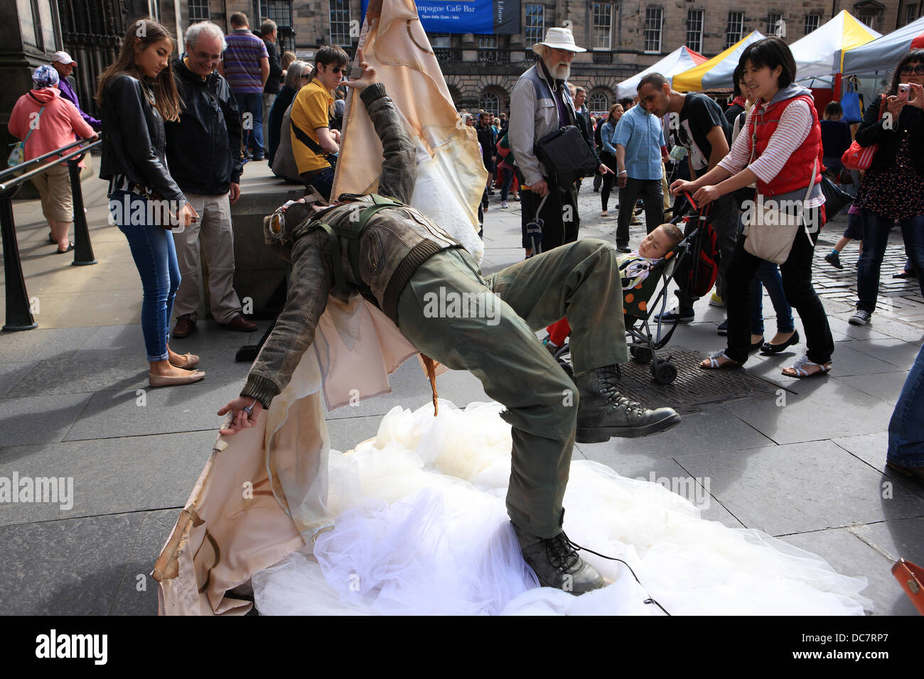 Edinburgh, Royaume-Uni. Août 11, 2013. Passants sur le Royal Mile d'Édimbourg se divertir en regardant un artiste de rue habillés comme Amelia Earhart. Credit : PictureScotland/Alamy Live News Banque D'Images