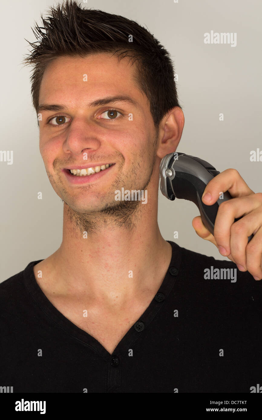 Man shaving face with electric razor Banque D'Images