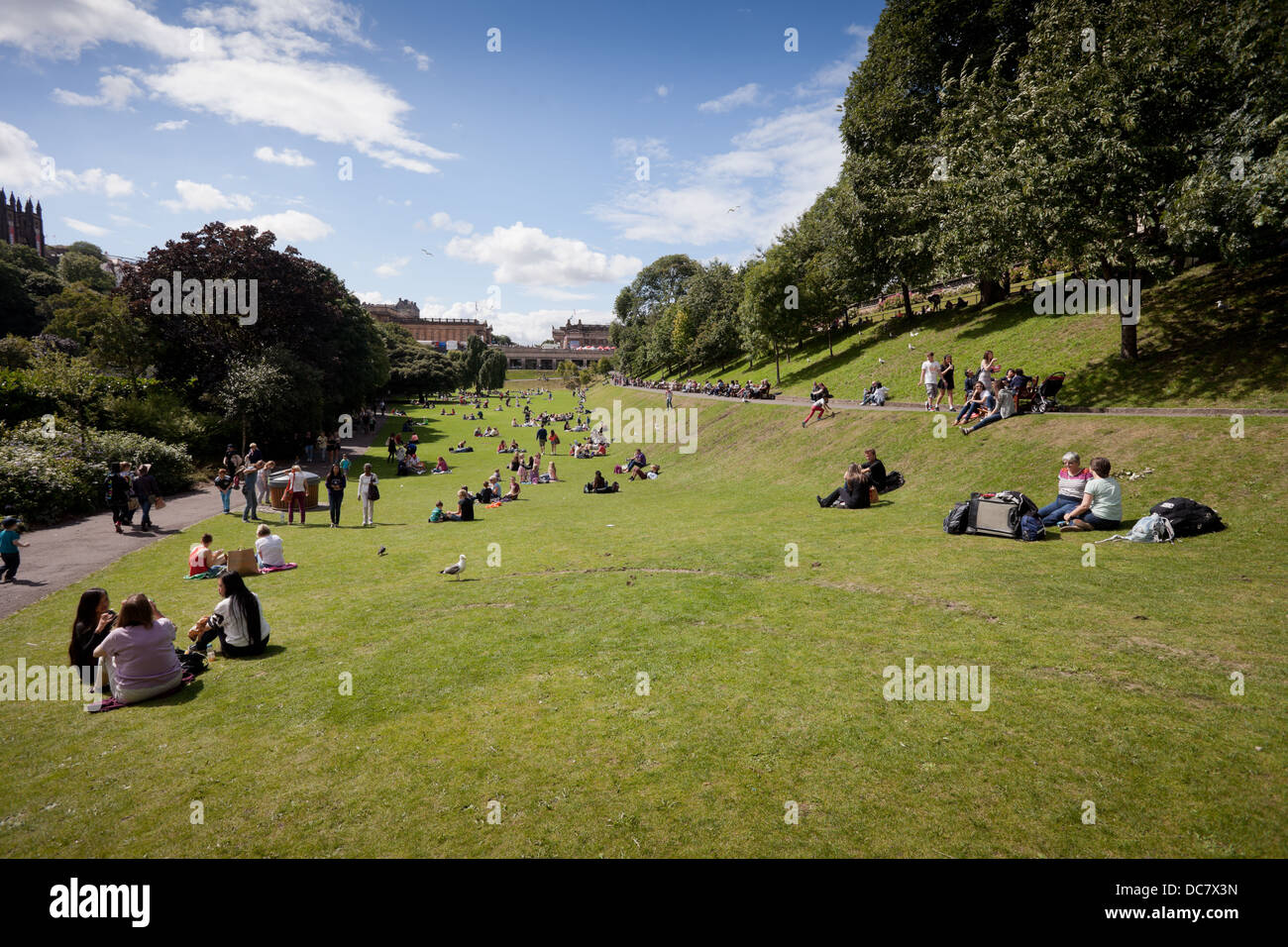 Les gens se détendre sur l'herbe des jardins de Princes Street, Edinburgh, Scotland UK Banque D'Images