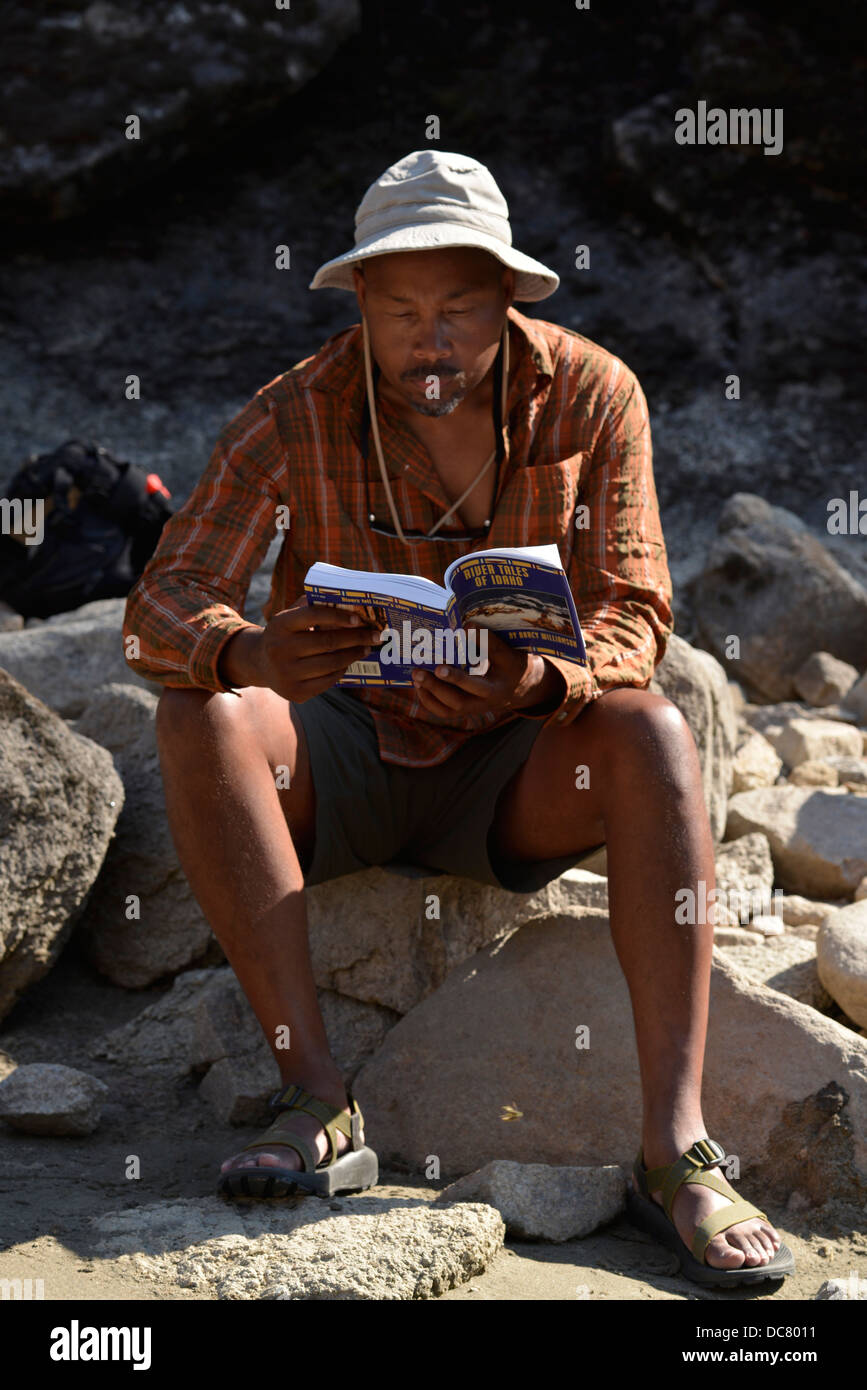 La lecture d'un livre dans un camping le long de la rivière Salmon dans l'Idaho. Banque D'Images