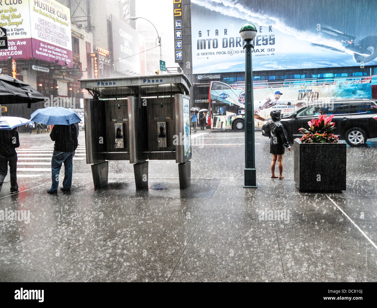 Le lavage au sluice déluge qui tombe la pluie rebondit sur trottoir que peu de piétons attendre de traverser Manhattan Broadway lors de fortes pluies Banque D'Images