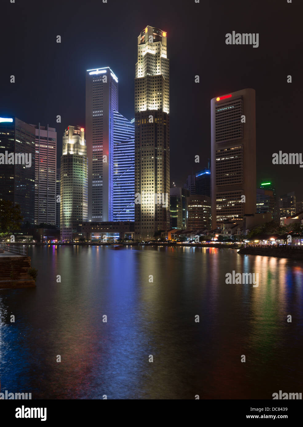 Quay Singapour avec de grands gratte-ciel lumineux dans le quartier central des affaires de nuit Banque D'Images