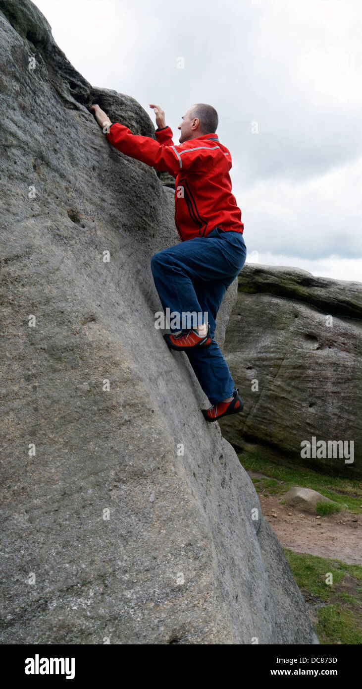 Rock climber Doug Blane bouldering à Burbage Edge, Sud, Derbyshire Peak District National Park, Angleterre, Royaume-Uni, États-Unis, Royaume Uni, Banque D'Images