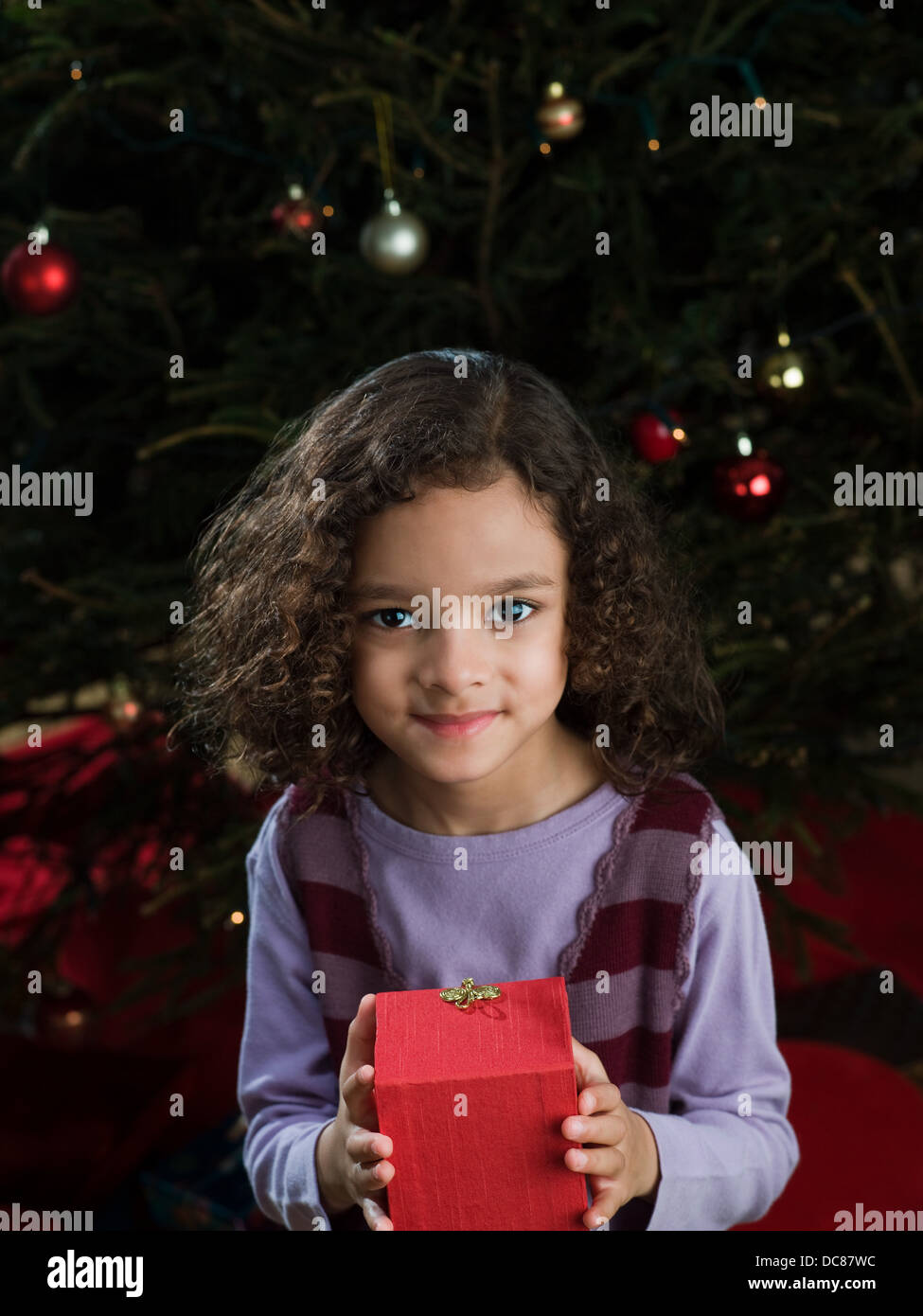 Girl holding christmas gift en boîte rouge Banque D'Images