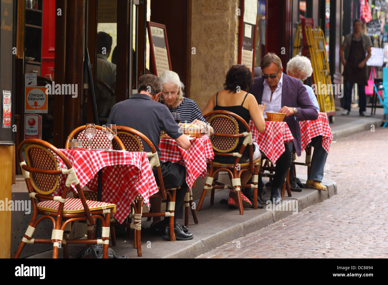 Les personnes mangeant dans l'un des cafés français traditionnel en plein air sur la rue Mouffetard à Paris, France Banque D'Images