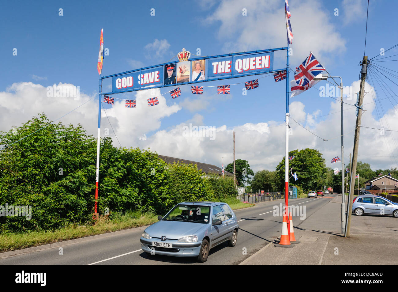 Un passage de l'orange au-dessus d'une route dans la région de Kilkeel avec des drapeaux, des photos de la Reine et le Prince William, avec "God save the Queen' Banque D'Images