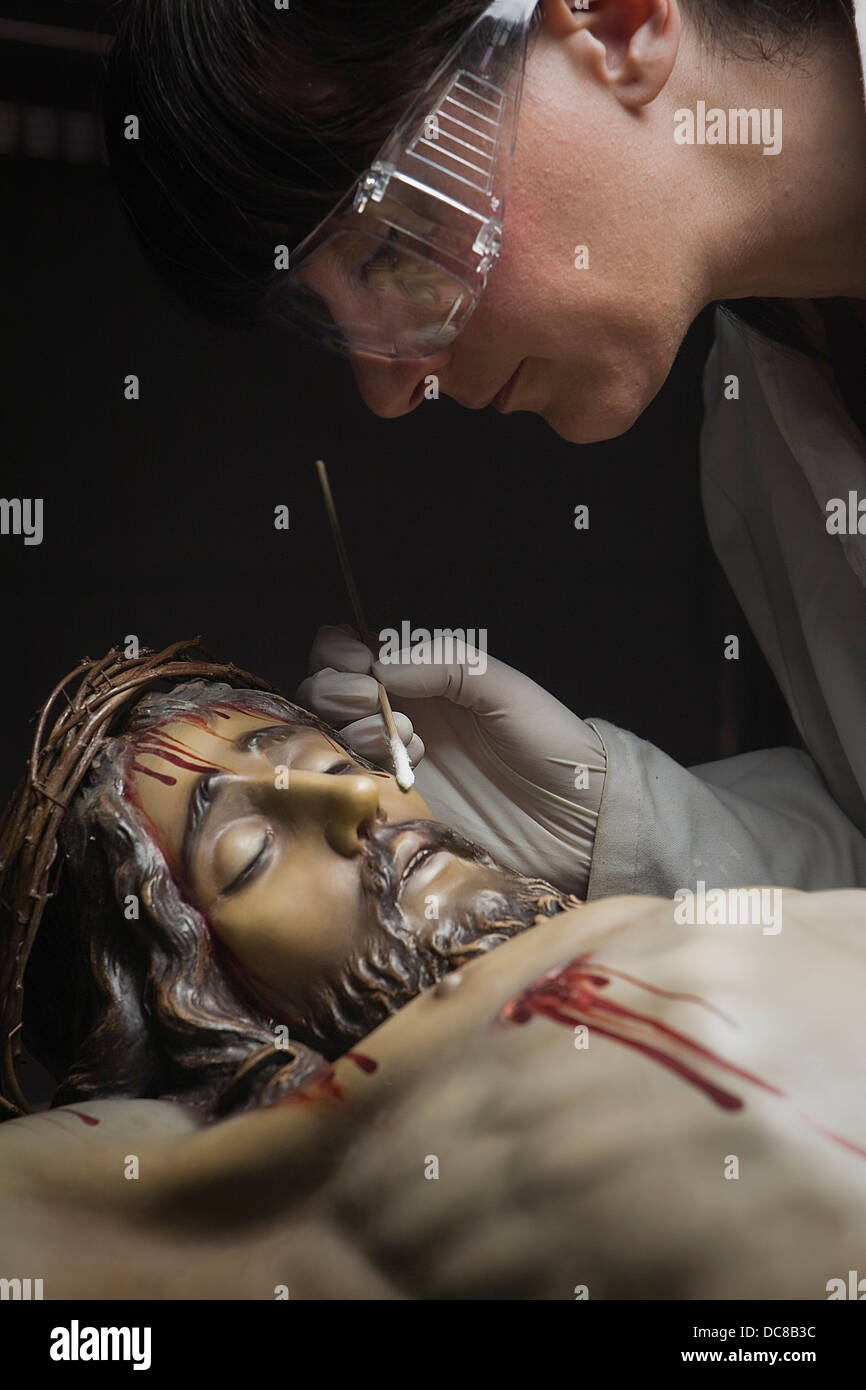 Nettoyage du visage d'une sculpture en bois du Christ avec un isopo imprégné de diméthylformamide, Andalousie, Espagne Banque D'Images
