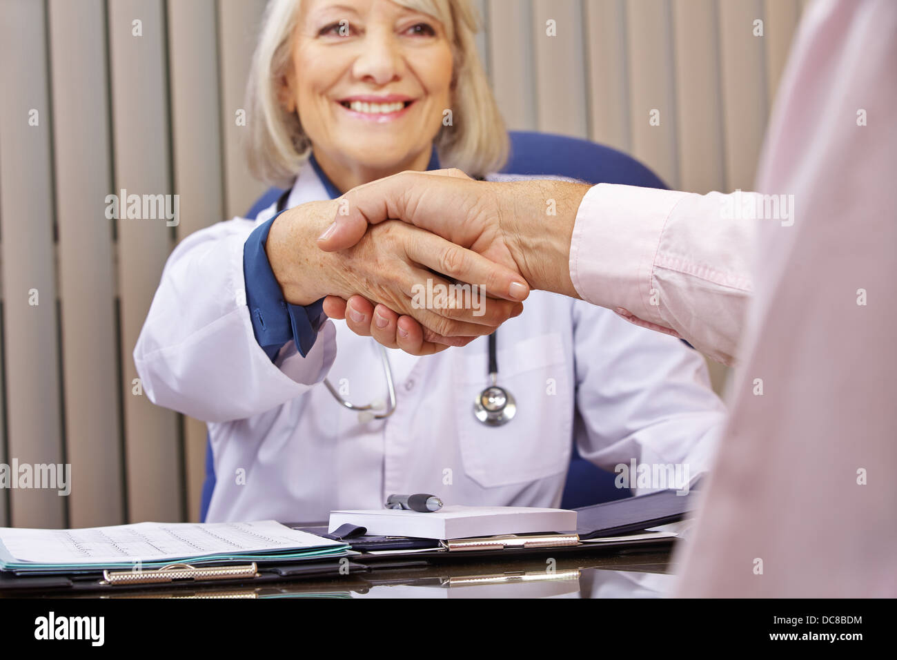 Smiling doctor and patient donnant prise après une consultation Banque D'Images