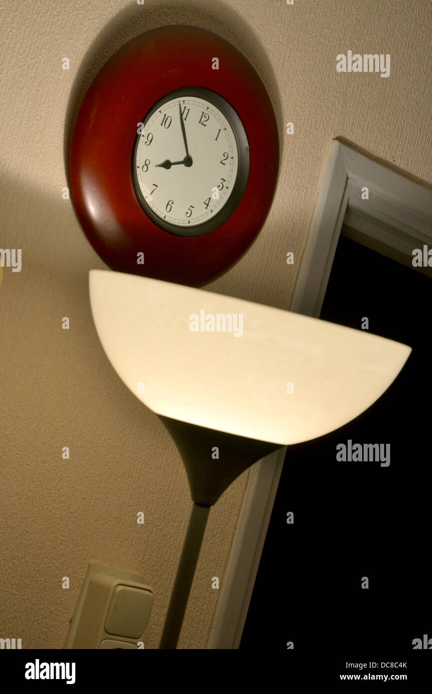 Lampe de plancher, des ombres dramatiques, wall clock Banque D'Images