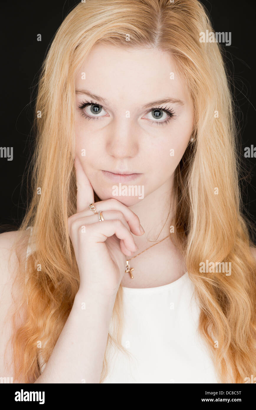 Jeune blonde female teenager looking at camera with serious expression Banque D'Images