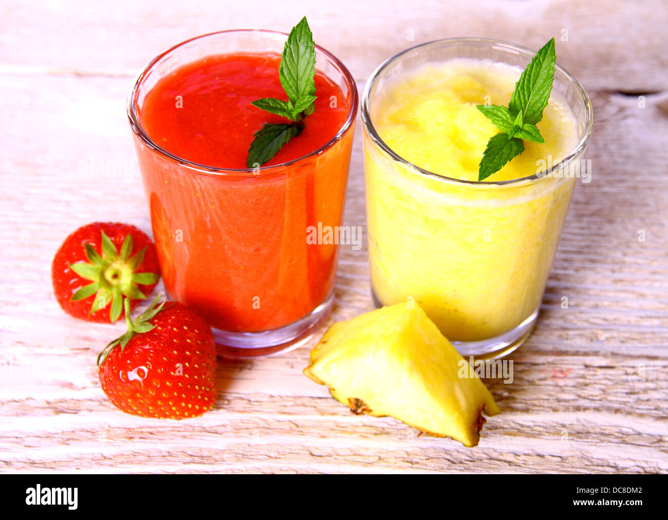 Smoothie ananas, fraises en verre, menthe, ananas tranche, soft focus Banque D'Images