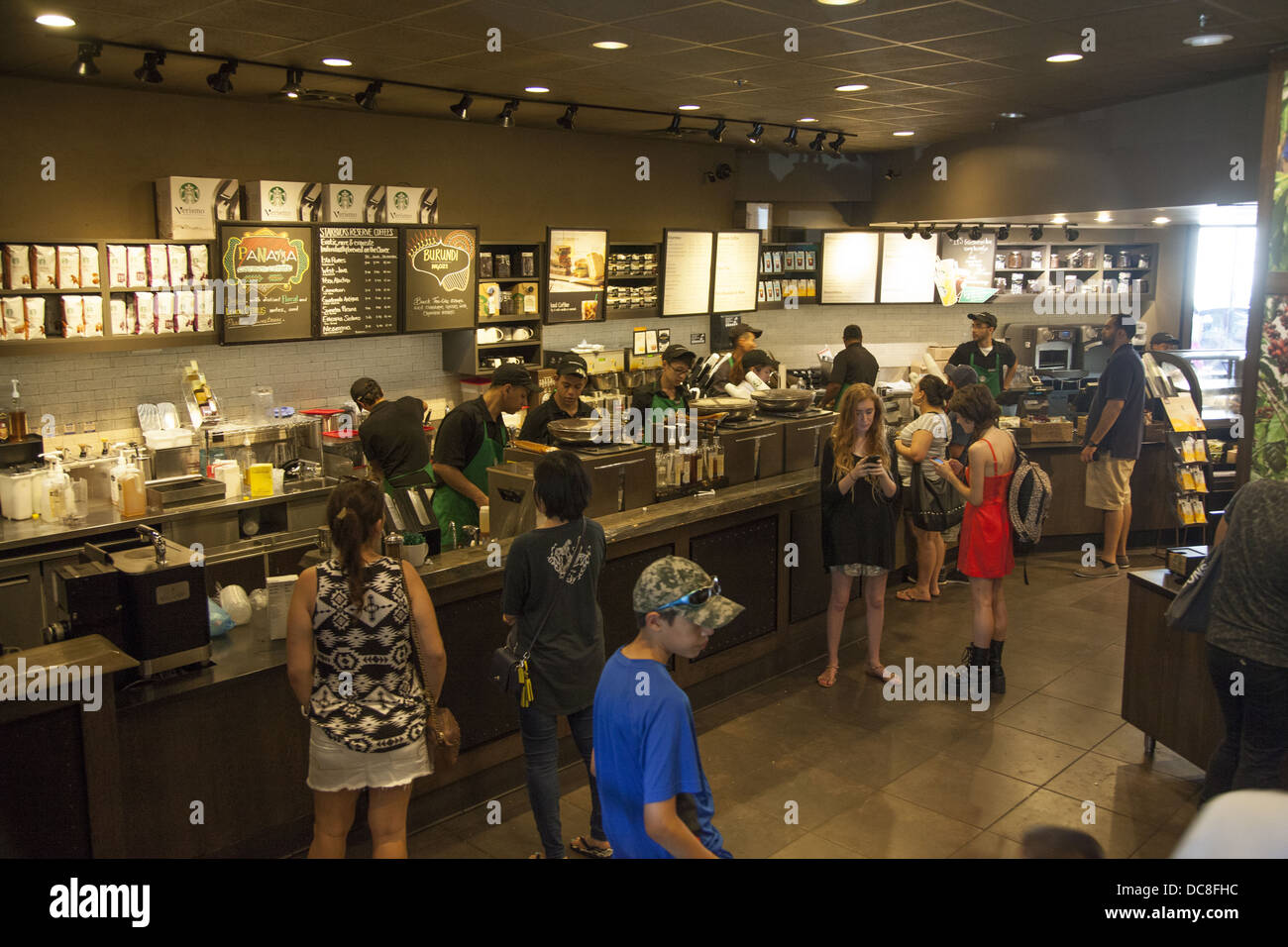 Les gens achètent du café frais et autres boissons sucrées sur une chaude journée d'été chez Starbucks à New York City Banque D'Images