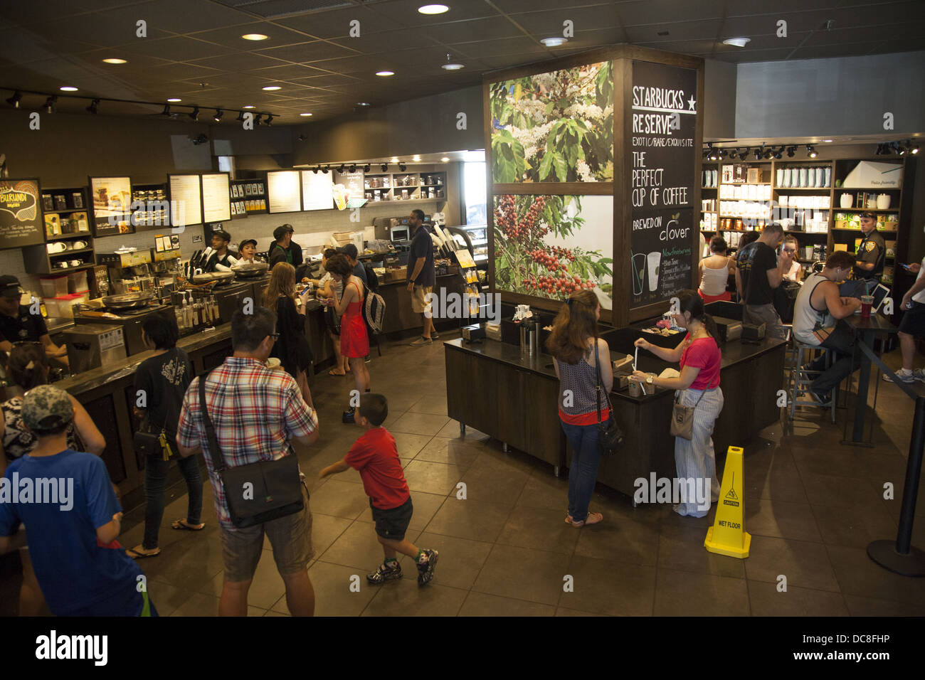 Les gens achètent du café frais et autres boissons sucrées sur une chaude journée d'été chez Starbucks à New York City Banque D'Images