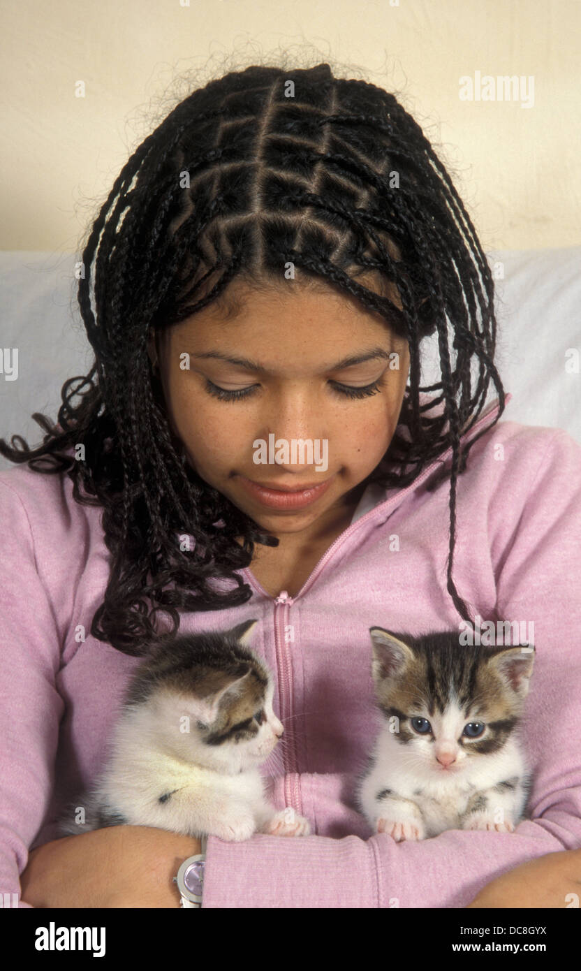 Bi-raciale teenage girl holding deux jeunes chatons Banque D'Images