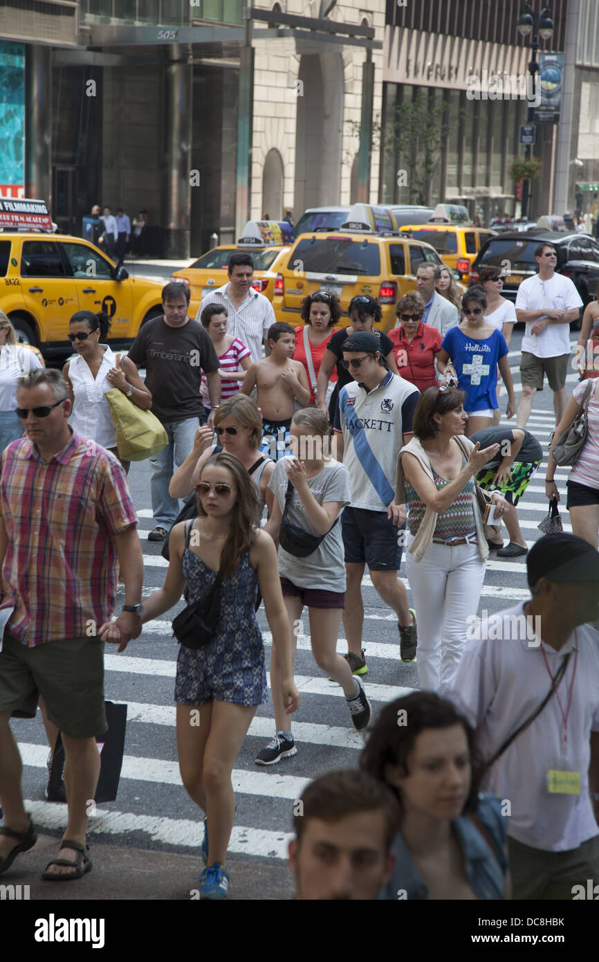 Les gens à la rue au croiserai toujours bondé intersection de la 5e Avenue et 42e Rue, New York. Banque D'Images