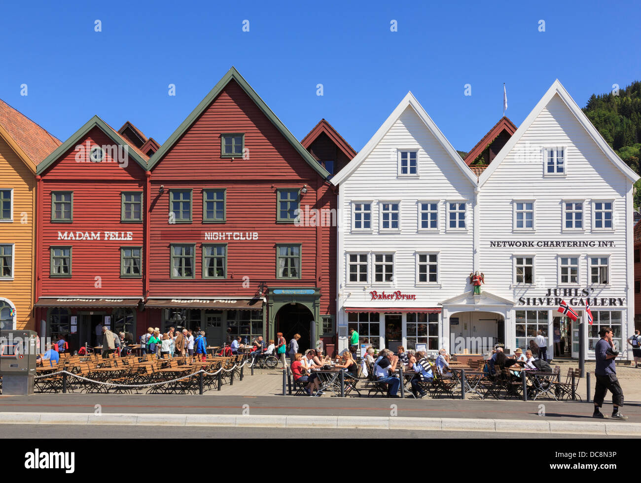 Les gens dans la rue en plein air restaurants par bâtiments en bois historique en été sur Bryggen, Bergen, Hordaland, Norvège, Scandinavie Banque D'Images