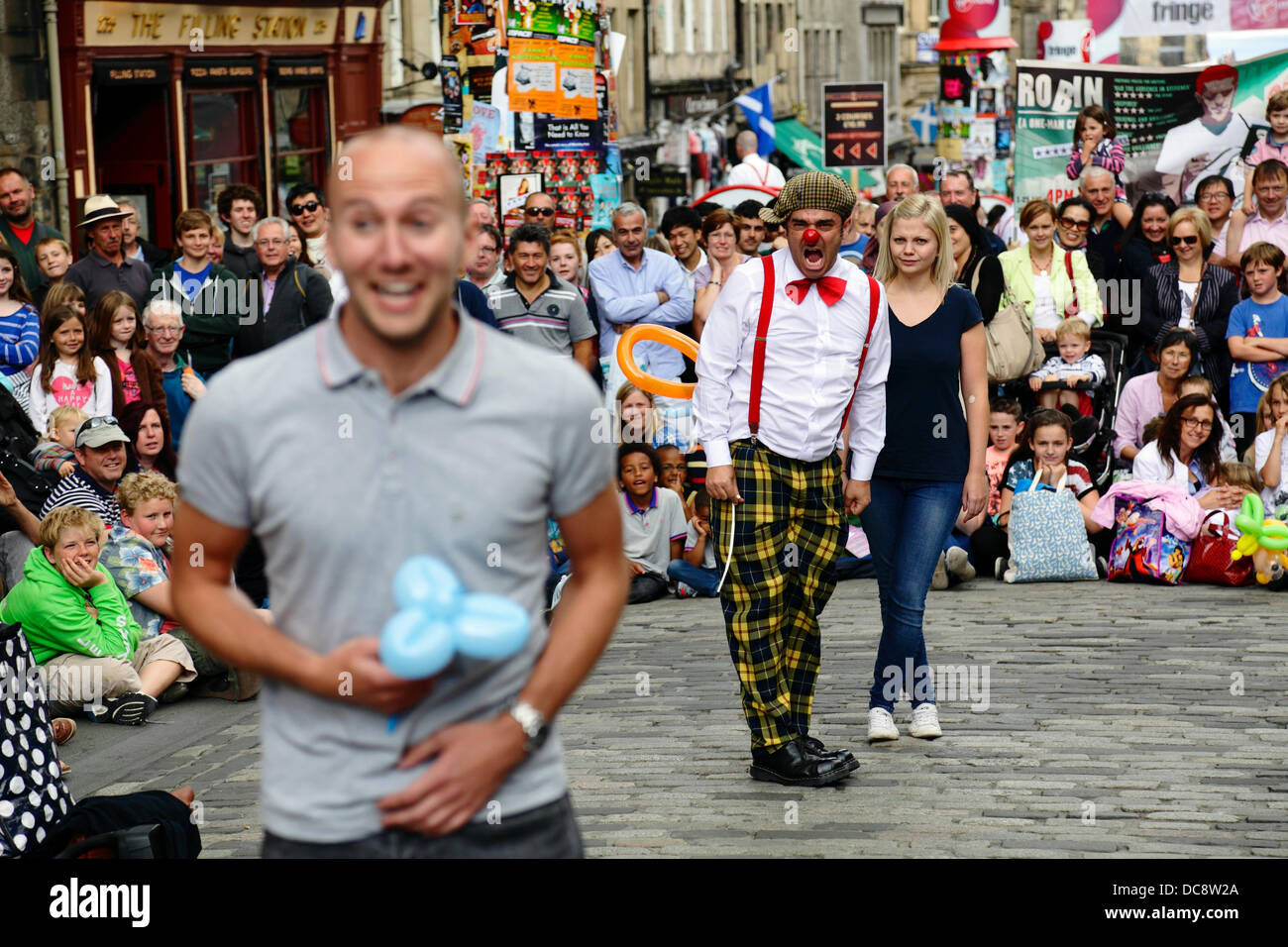 Royal Mile, Édimbourg, Écosse, Royaume-Uni, lundi 12 août 2013. Le comédien du clown de la rue Performer Pedro Tochas du Portugal divertit une foule avec l'aide de bénévoles de l'auditoire pendant le Festival International Fringe d'Édimbourg Banque D'Images
