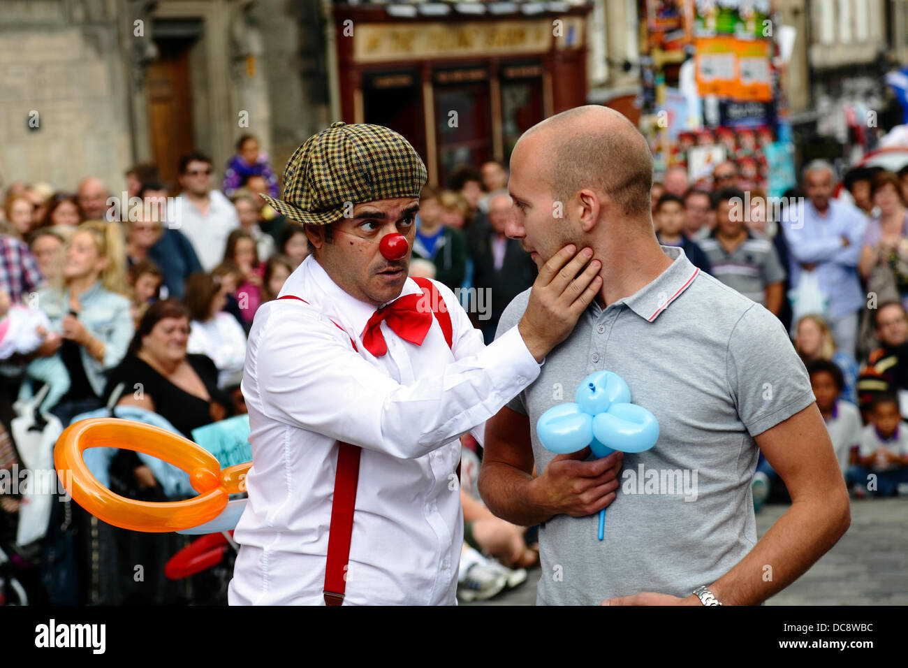 Royal Mile, Édimbourg, Écosse, Royaume-Uni, lundi 12 août 2013. Le comédien du clown de la rue Performer Pedro Tochas du Portugal divertit une foule avec l'aide d'un public bénévole pendant le Festival International Fringe d'Édimbourg Banque D'Images