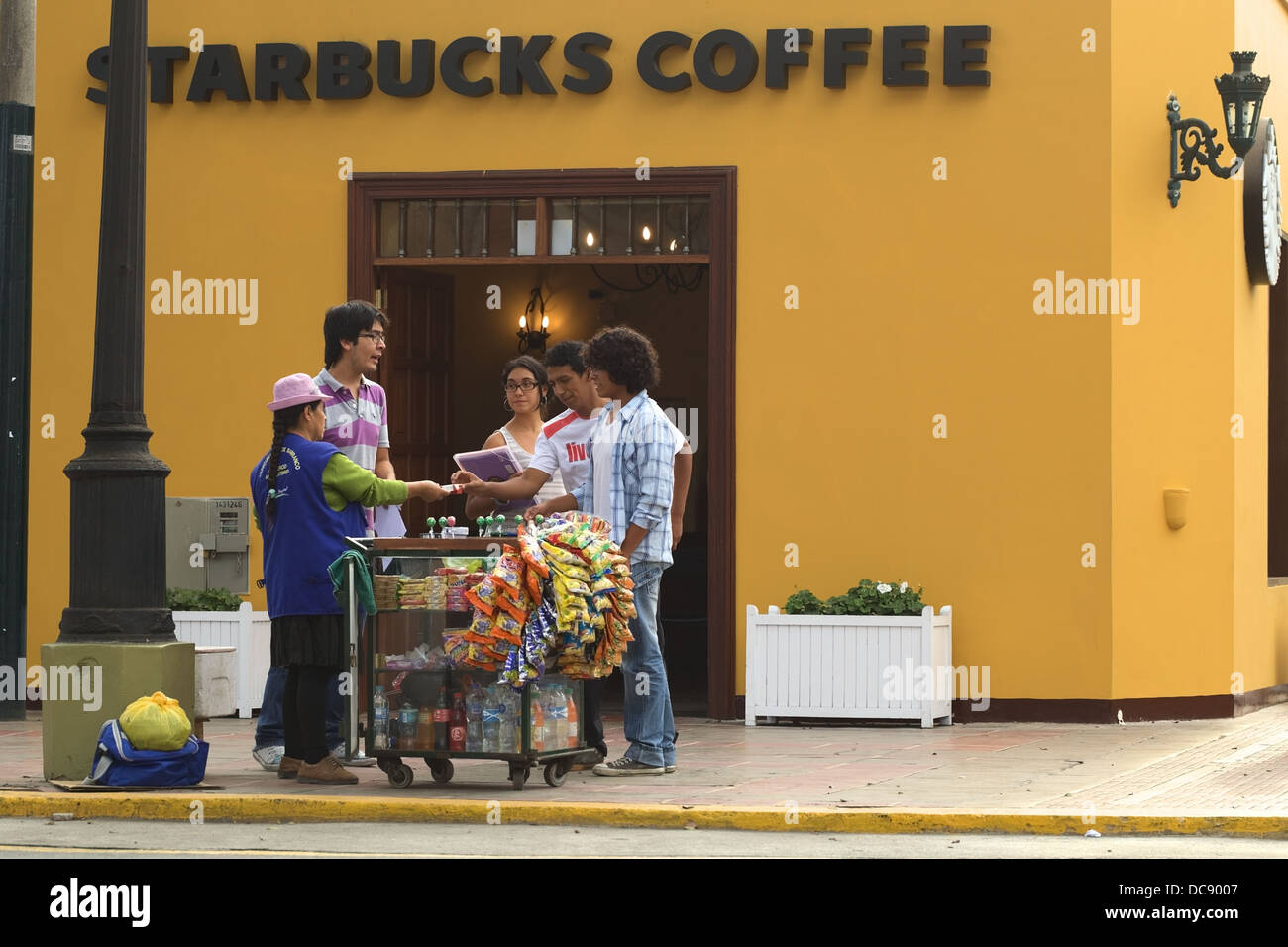 Vendeur de rue, avec un petit panier de boissons et de collations en face du café Starbucks dans le district de Barranco, Lima, Pérou Banque D'Images