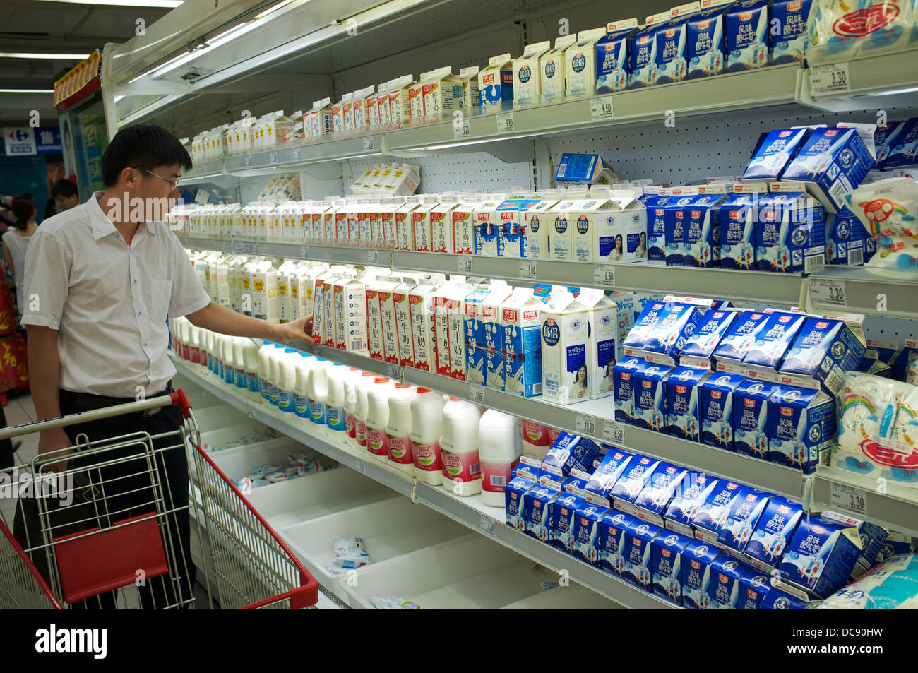 Un homme d'acheter des produits dans un supermarché Carrefour à Beijing, Chine. 2013 Banque D'Images